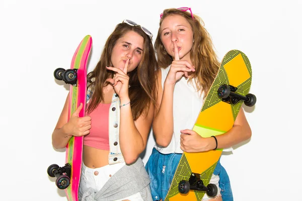 Two friends with their skateboards making silence gesture — Stock Photo, Image