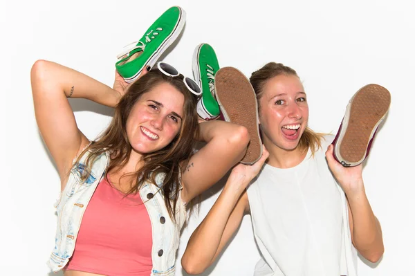 Galna tjejer hålla skor — Stockfoto
