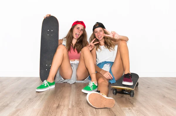 Amigos com seus skates fazendo gesto de vitória — Fotografia de Stock