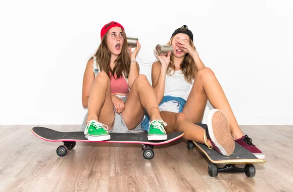 Amigos com seus skates falando através de um telefone de lata — Fotografia de Stock