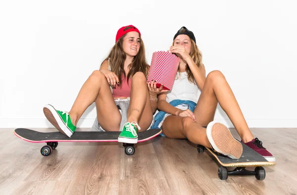 Amigos com seus skates comendo pipocas — Fotografia de Stock