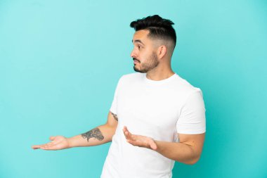 Mavi arka planda mahsur kalmış beyaz bir genç var.