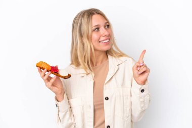 Beyaz arka planda saşimi tutan beyaz bir kadın harika bir fikre işaret ediyor.