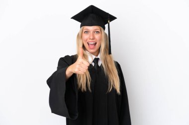 Genç üniversite mezunu beyaz arka planda izole edilmiş beyaz bir kadın. Başparmakları havada çünkü iyi bir şey oldu.