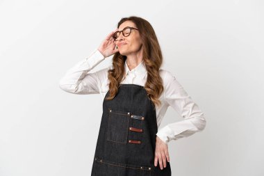 Restorandaki orta yaşlı garson kadın beyaz arka planda izole edilmiş bir şeyin farkına vardı ve çözüme niyetlendi.