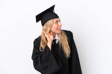 Beyaz arka planda izole edilmiş genç üniversite mezunu bir kadın elini kulağına koyarak bir şeyler dinliyor.