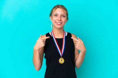 Mavi arka planda madalyalı beyaz bir kadın. Yüzünde sürpriz bir ifade var.