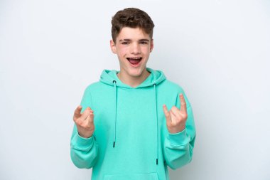 Beyaz arka planda izole edilmiş genç Rus adam boynuz hareketi yapıyor.