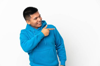 Beyaz arka planda izole edilmiş genç Ekvador 'lu adam parmağını yana doğru uzattı ve bir ürün sundu.