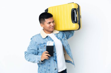 Genç Ekvadorlu adam beyaz arka planda izole edilmiş, bavul ve pasaportla tatilde.