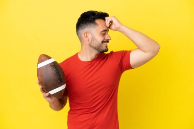 Sarı arka planda ragbi oynayan genç beyaz adam bir şeyin farkına vardı ve çözüme niyetlendi.