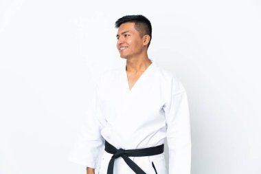 Genç Ekvadorlu adam beyaz arka planda karate yapıyor.