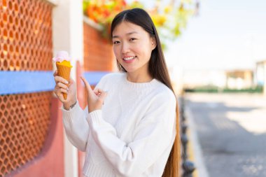 Açık havada kornet dondurması olan güzel bir Çinli kadın.