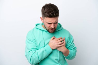 Beyaz arka planda izole edilmiş genç beyaz bir adam kalbinde bir ağrı var.