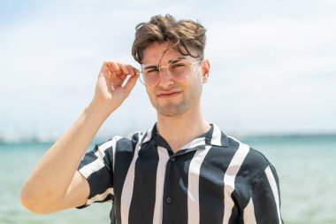 Gözlüklü ve hayal kırıklığına uğramış genç yakışıklı adam.