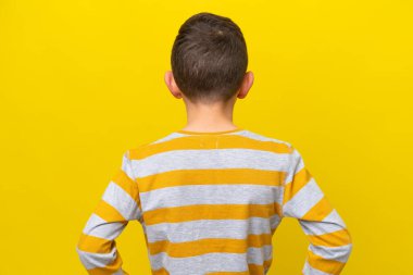 Küçük beyaz çocuk sarı arka planda izole edilmiş.