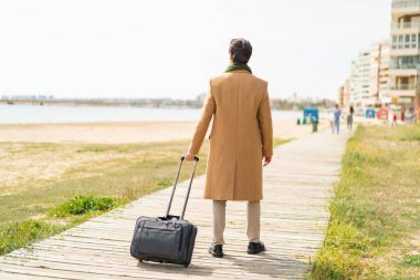 Dışarıda bavullu yakışıklı bir delikanlı var.