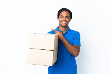 Beyaz arka planda örgü ören Afrikalı Amerikalı bir adam bir ürün sunmak için yan tarafı işaret ediyor.