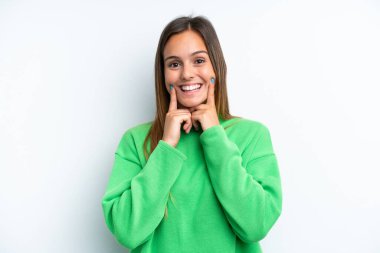 Beyaz arka planda izole edilmiş genç beyaz kadın mutlu ve hoş bir ifadeyle gülümsüyor.