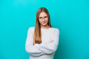 Genç Rus kadın mutsuz bir ifadeyle mavi arka planda izole edilmiş.