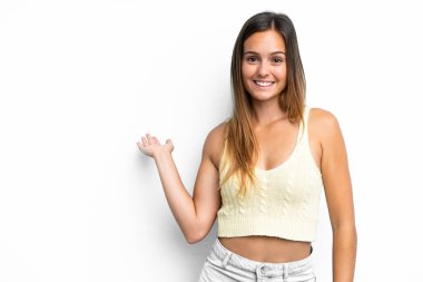 Beyaz arka planda soyutlanmış beyaz tenli genç bir kadın davet edilmek için ellerini yana uzatıyor.