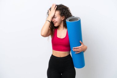 Beyaz arka planda izole edilmiş bir minderi tutarak yoga derslerine giden genç Arap kadın bir şey fark etti ve çözüme niyetlendi.