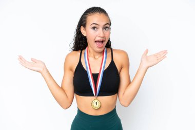 Yüzünde şok ifadesi olan beyaz arka planda madalyaları olan genç bir bayan.