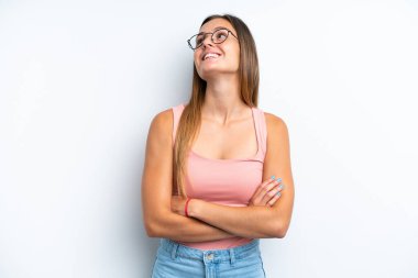 Beyaz arka planda izole edilmiş genç beyaz kadın mutlu ve gülümsüyor.