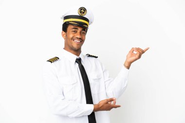 İzole edilmiş beyaz arka plan üzerinde Afrikalı Amerikan Uçak Pilotu davet edilmek için elini yana uzatıyor