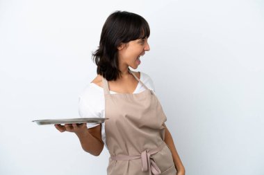 Tepsisi beyaz arka plan izole genç garson yan pozisyonda gülüyor