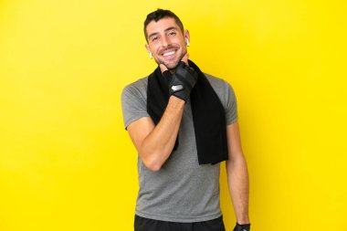 Sarı arka planda izole edilmiş genç beyaz adam gülümsüyor.