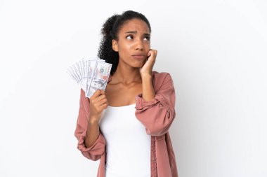 Genç Afrikalı Amerikalı bir kadın, beyaz arka planda izole edilmiş, hayal kırıklığına uğramış ve kulaklarını tıkayan bir sürü para alıyor.