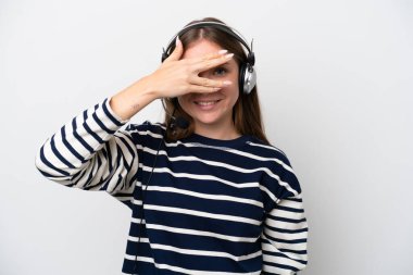 Tele pazarlamacı, beyaz arka planda izole edilmiş kulaklıkla çalışan beyaz bir kadın gözleri elleriyle kaplıyor ve gülümsüyor.