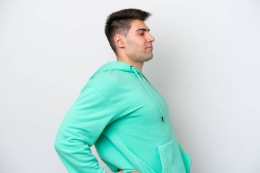 Beyaz arka planda izole edilmiş beyaz bir beyaz adam gayret gösterdiği için sırt ağrısı çekiyor.