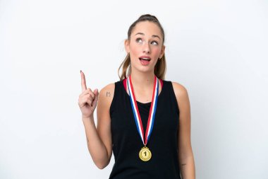 Young caucasian woman with medals isolated on white background pointing up and surprised