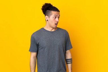 İzole edilmiş arka planda beyaz bir adam yan tarafa bakarken sürpriz jest yapıyor.