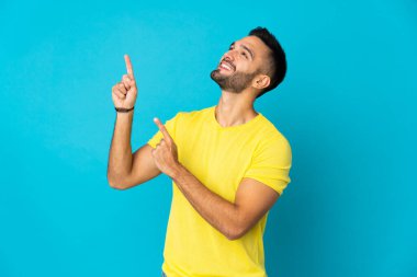 Mavi arka planda izole edilmiş genç beyaz adam işaret parmağıyla işaret etmek harika bir fikir.