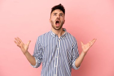 Pembe arka planda izole edilmiş genç beyaz adam bunalıma girdi.