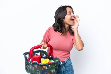 Elinde yiyecek dolu bir sepet tutan genç bir kadın ağzı açık bağırıyor.