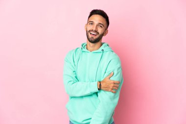 Pembe arka planda izole edilmiş genç beyaz adam gülüyor.