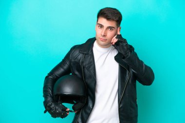 Motosiklet kasklı genç beyaz adam mavi arka planda izole edilmiş bir fikir düşünüyor.