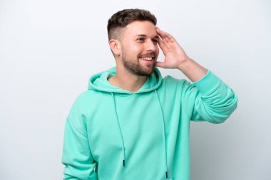 Beyaz arka planda izole edilmiş genç beyaz adam çok gülümsüyor.