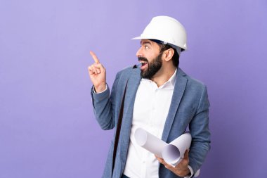 Miğferli genç bir mimar, elinde mor arkaplan üzerine planlar tutuyor. Çözümü bulmak için parmağını kaldırıyor.