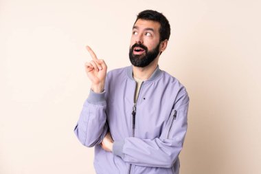 İzole edilmiş arka plan üzerinde ceket giyen beyaz sakallı bir adam, bir fikrin parmağı yukarı kaldırdığını düşünüyor.