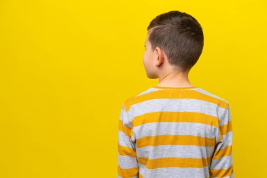 Küçük beyaz çocuk sarı arka planda izole edilmiş.