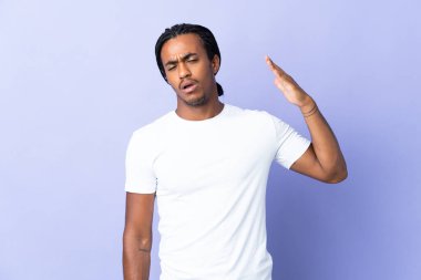 Örgülü genç Afrikalı Amerikalı adam mor arka planda izole edilmiş, yorgun ve hasta bir ifadeyle.