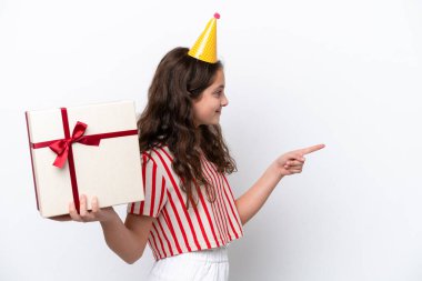 Parti şapkası takan, hediye kutusu tutan ve işaret eden kız.