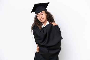 Genç üniversite mezunu Arap bir kadın beyaz arka planda izole edilmiş, omuz ağrısı çektiği için çaba sarf ediyor.