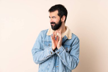 Kafkasyalı sakallı, soyutlanmış bir arka planı olan bir adam.