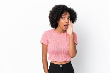 Beyaz arka planda izole edilmiş genç Afrikalı Amerikalı kadın yan tarafa bakarken sürpriz bir jest yapıyor.
